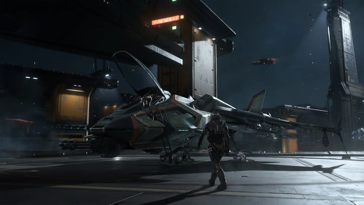 En pilot som står bredvid ett strömlinjeformat, grått rymdjaktskepp på ett futuristiskt hangardäck på en rymdstation i Squadron 42.